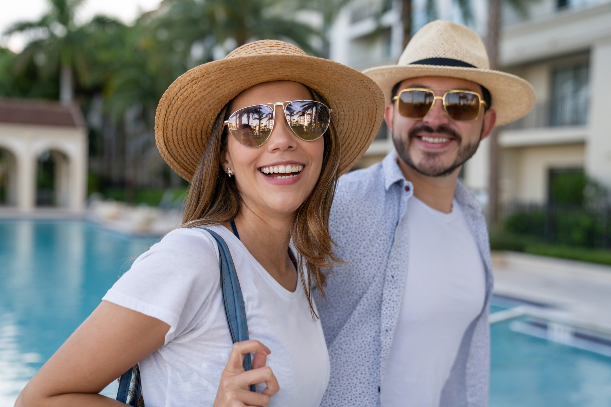 Portrait of a happy couple arriving at their holiday resort Portrait of a happy loving couple arriving at their holiday resort for their vacations and smiling
