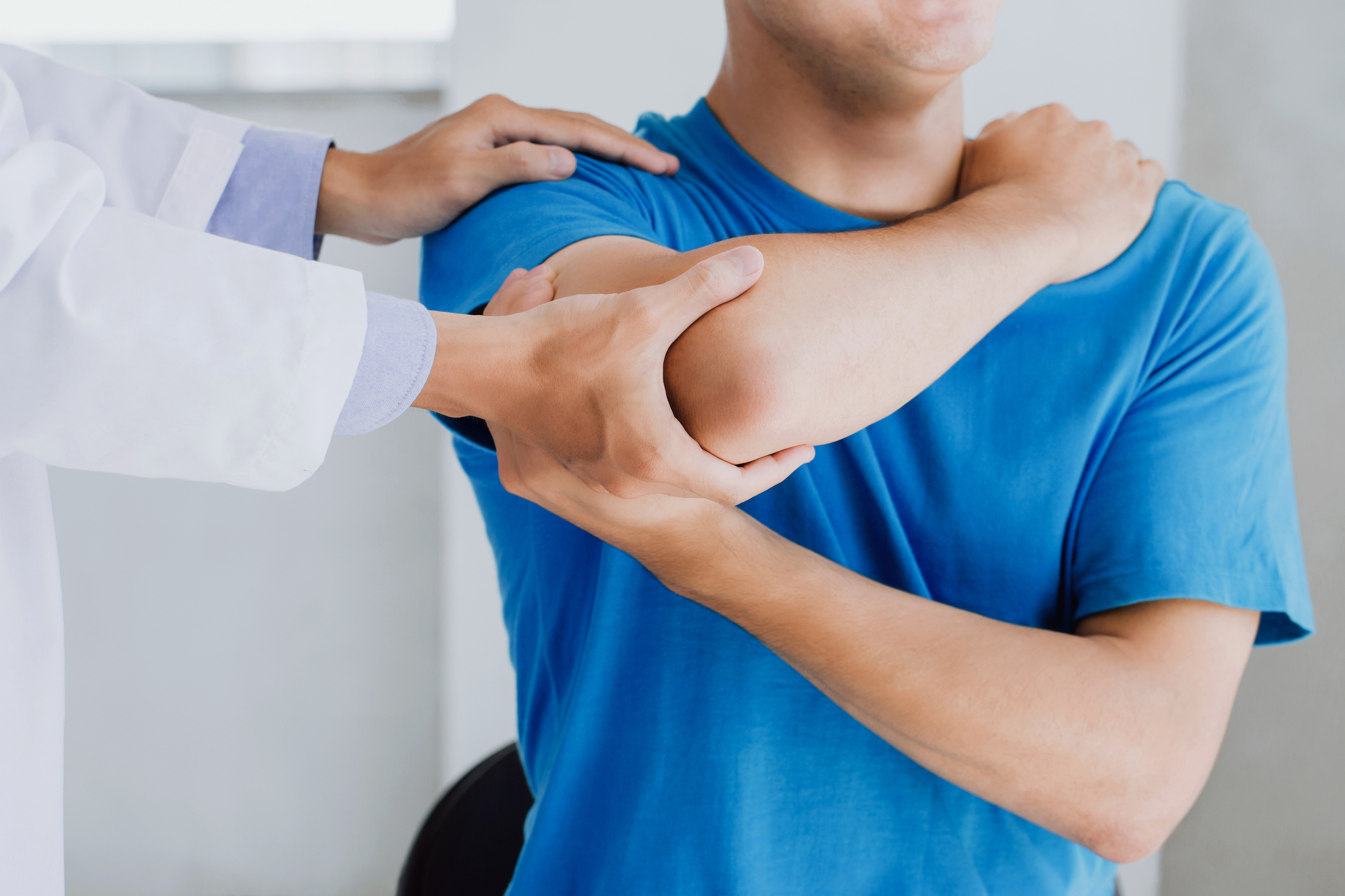 Professional physiotherapists provide assistance to male patients with arm injuries examine patients in clinic. Doing the Rehabilitation therapy pain in clinic.Rehabilitation physiotherapy concept.” Professional physiotherapists provide assistance to male patients with arm injuries examine patients in clinic doing rehabilitation therapy
