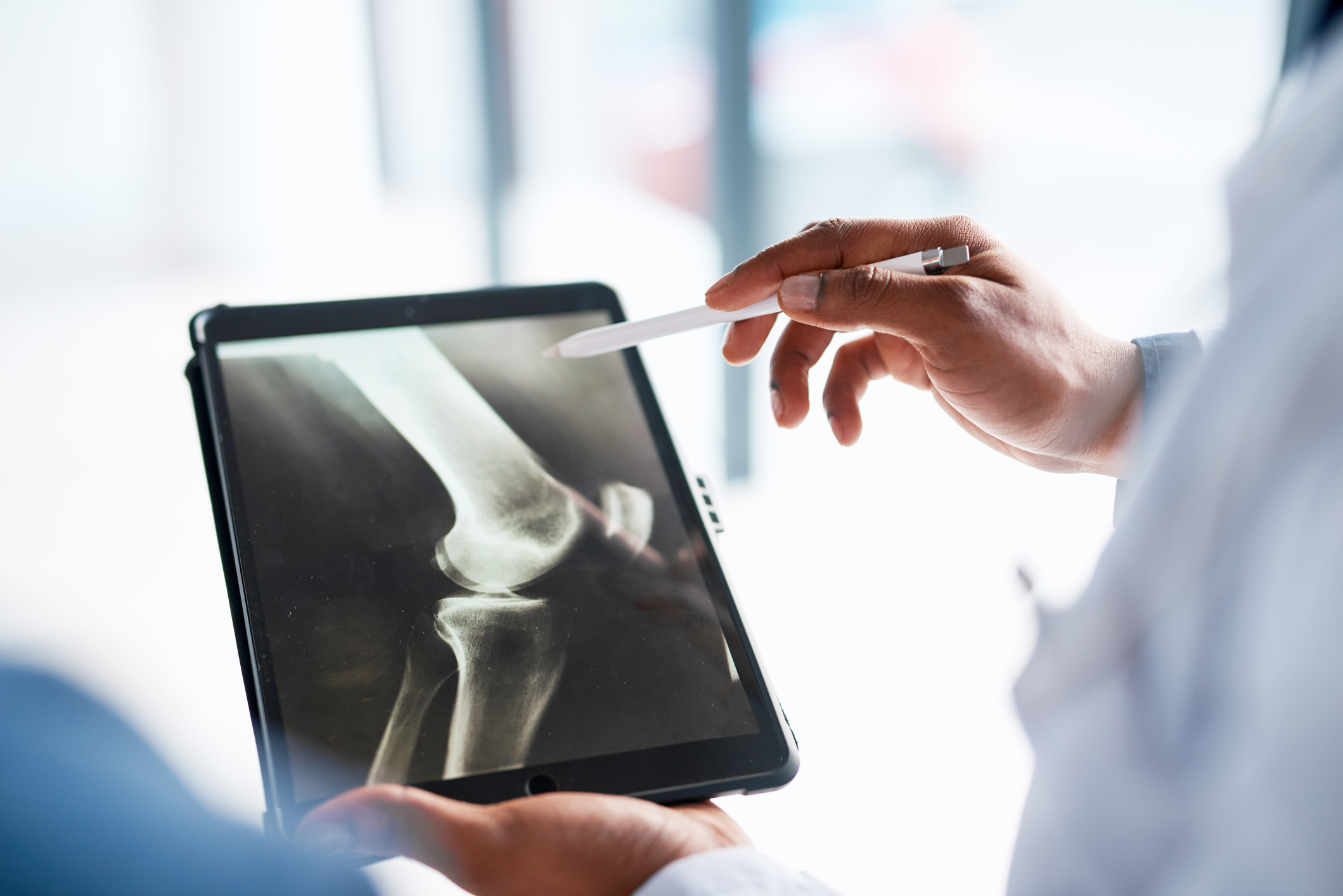 Hands, doctor and tablet with x ray in hospital for research, test results or exam in clinic